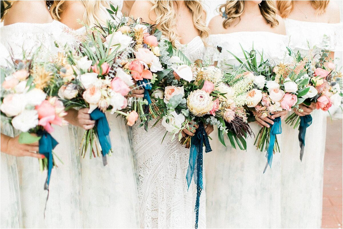 The bridesmaids' bouquets of protea and garden roses, teal silk trailing
