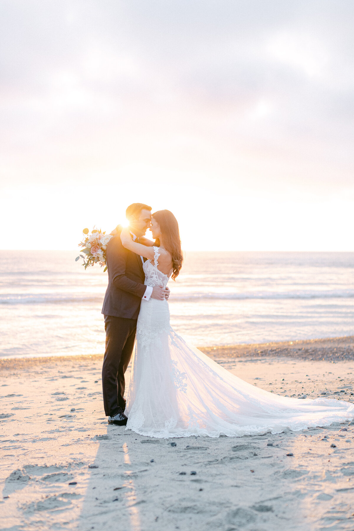 Foreheads together on the sand as the sun drops