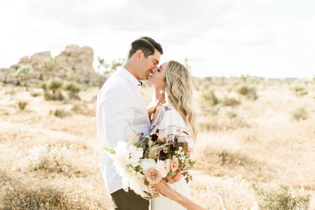 A kiss among the boulders and gold grass of the high desert