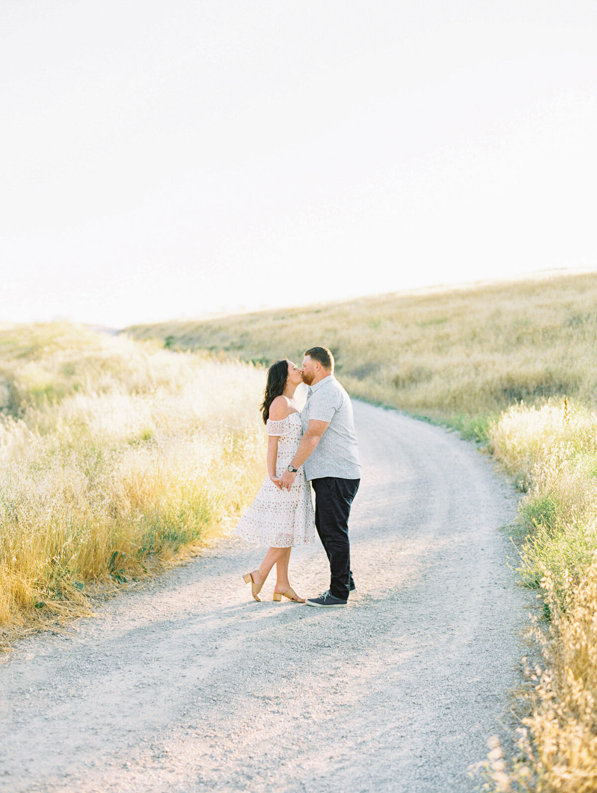 A kiss on the ranch road, summer grass gone to gold