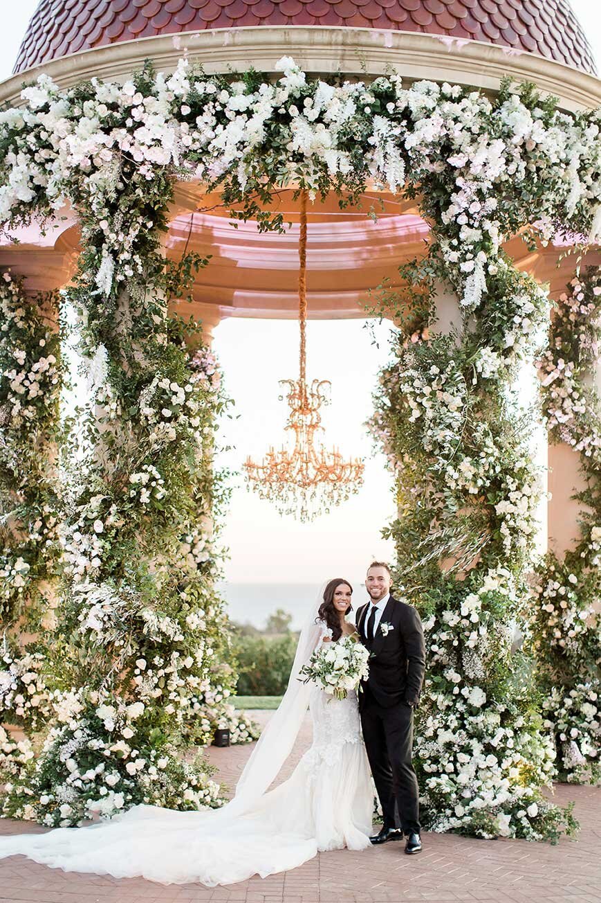 Beneath the rotunda at Pelican Hill, its columns wrapped in white roses, the chandelier hung from the dome