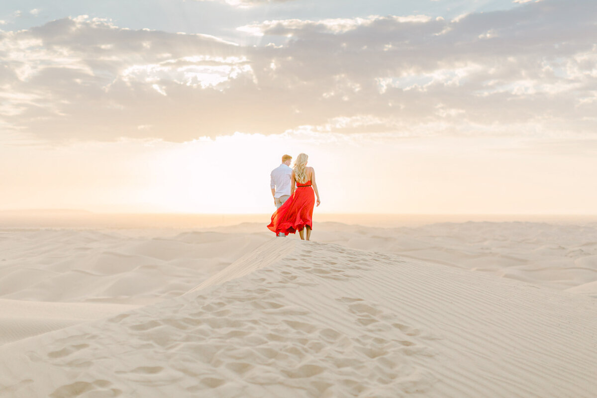 Her red dress in the wind on the ridge of the dunes