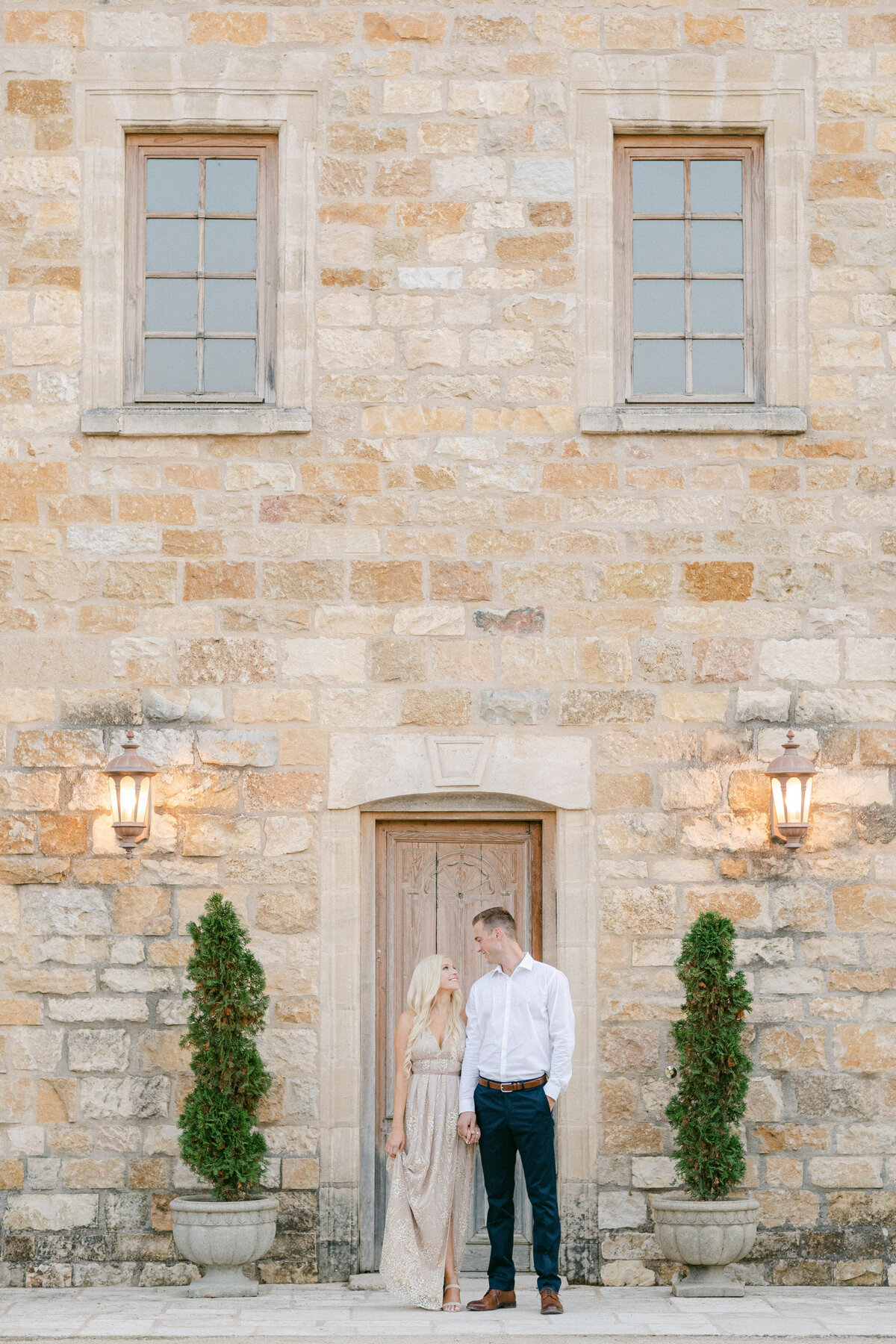 Hand in hand at the old stone doorway, lanterns lit