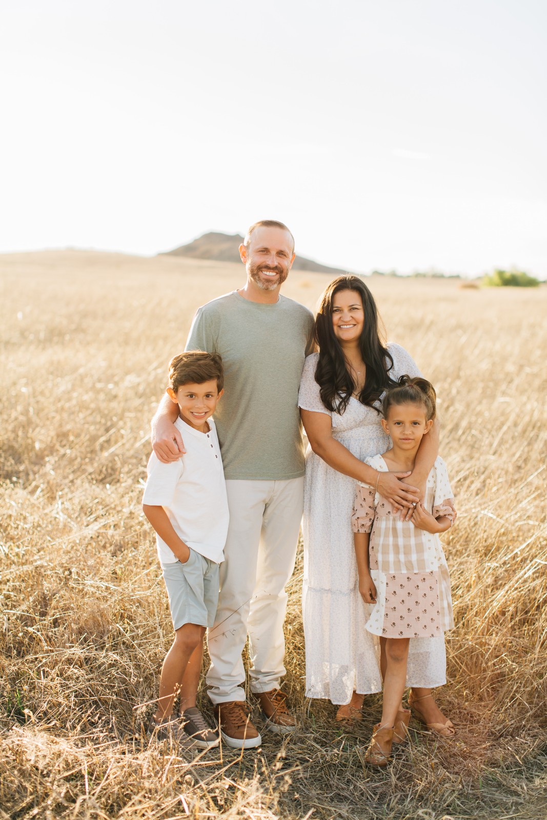 Brett Hickman with his wife Adriana and their two kids in a golden field
