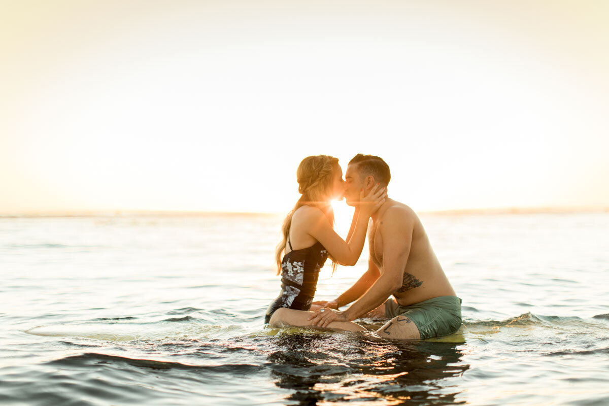A kiss out on the water, the board just under them
