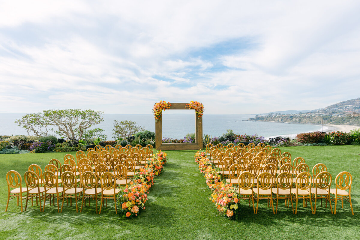 A square arch dressed in marigold and coral above the cove