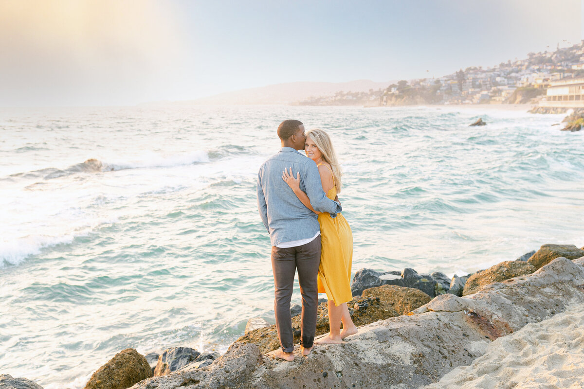 Her marigold dress on the rocks, the whole coastline behind them