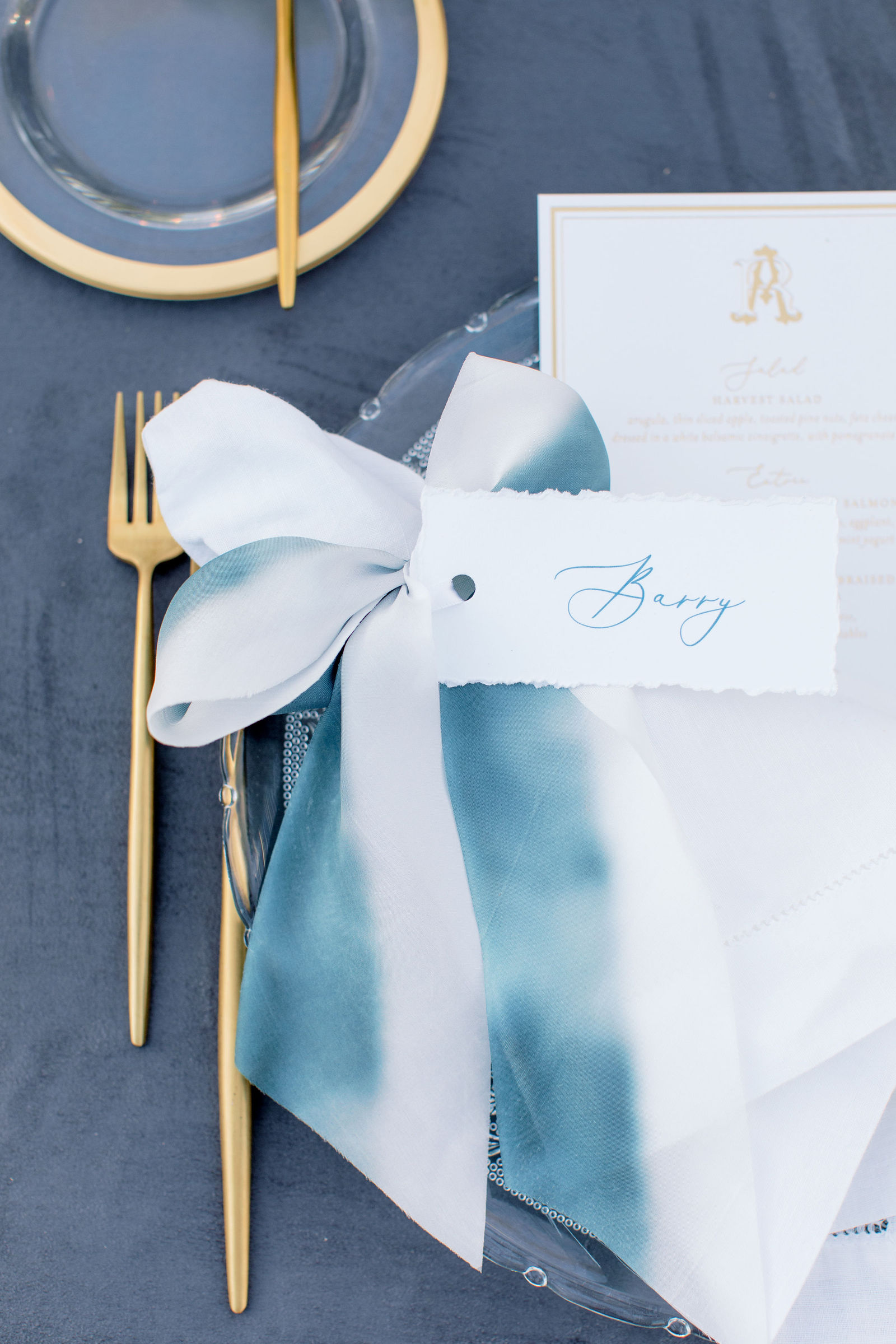 A ribboned napkin and place setting in blue and white