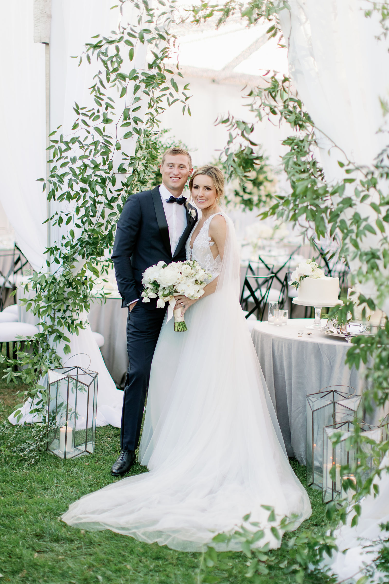 A kiss beneath the greenery arch
