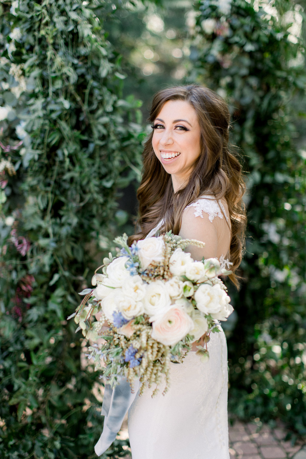 The bride with her white and green bouquet