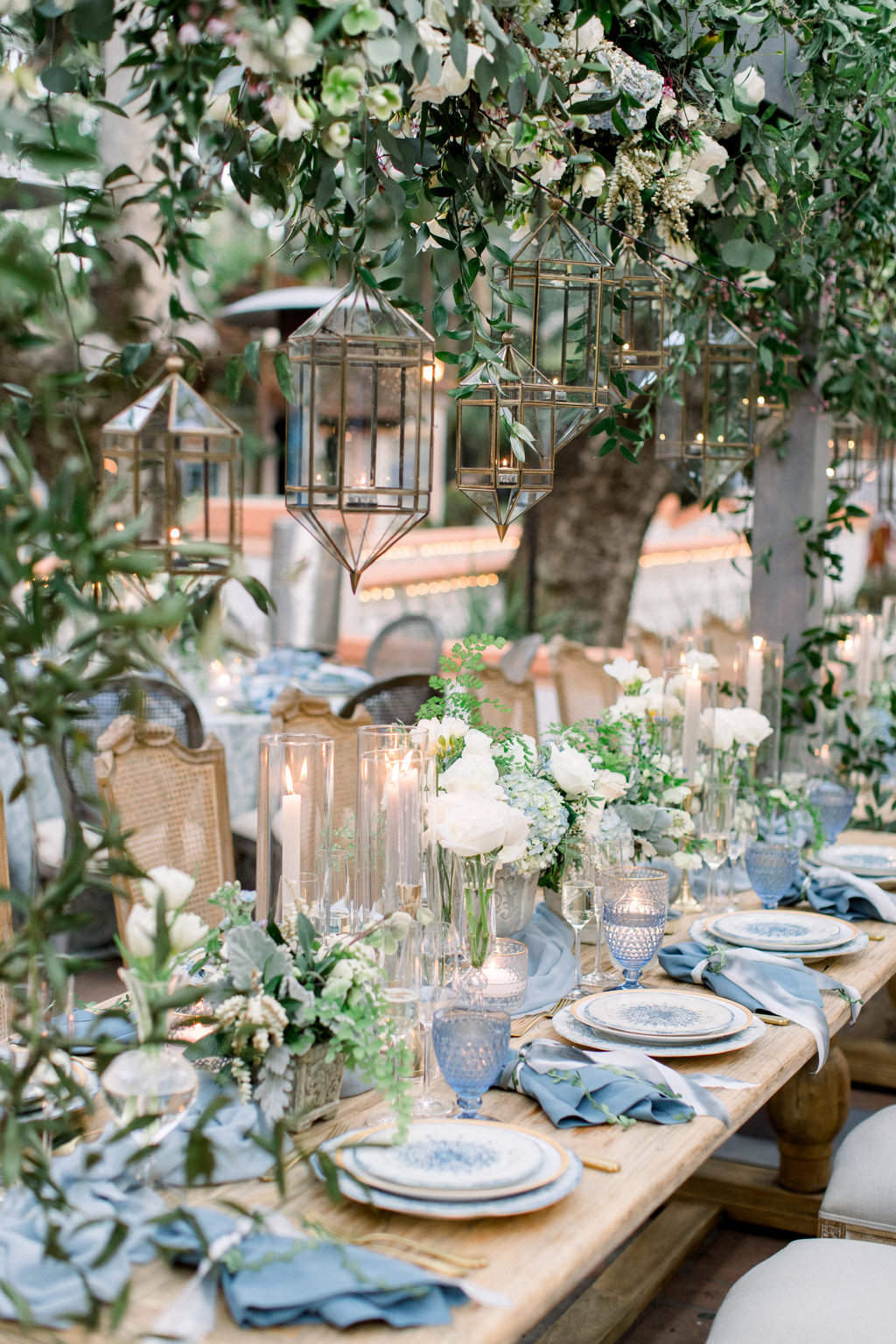 Looking down the length of the reception table at Rancho Las Lomas, blue and white china and candlelight