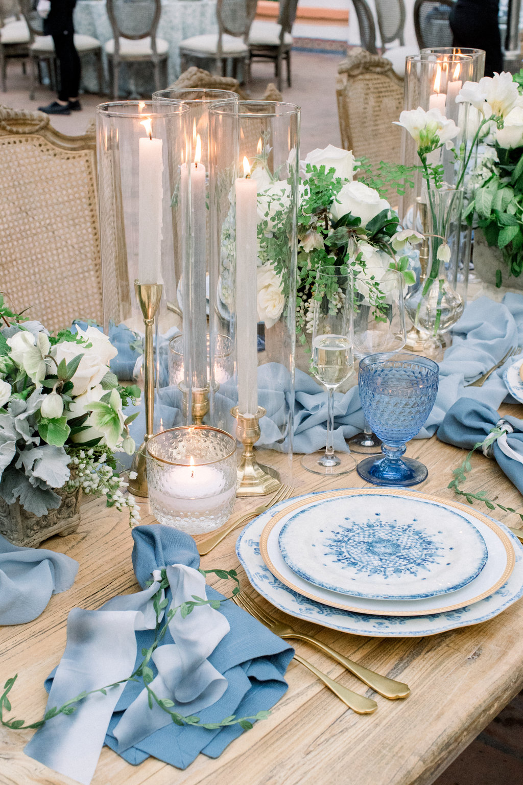 Blue napkins and white roses down the table