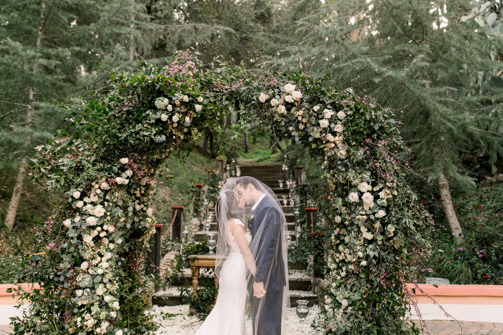 A kiss beneath the flowering arch