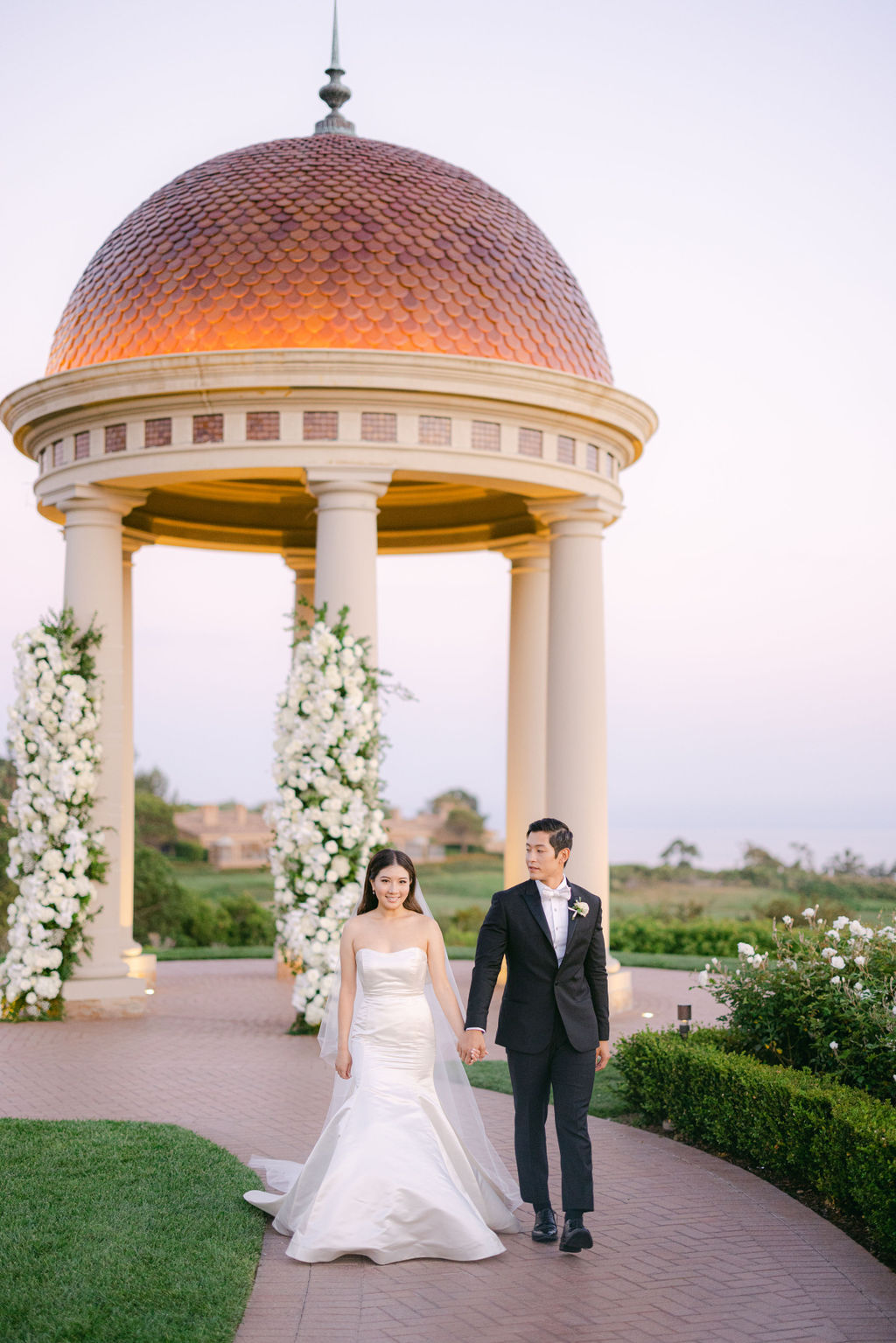 Bride and groom before the Pelican Hill rotunda at dusk