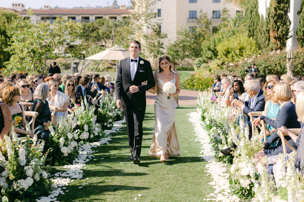 The processional down an aisle lined with white flowers