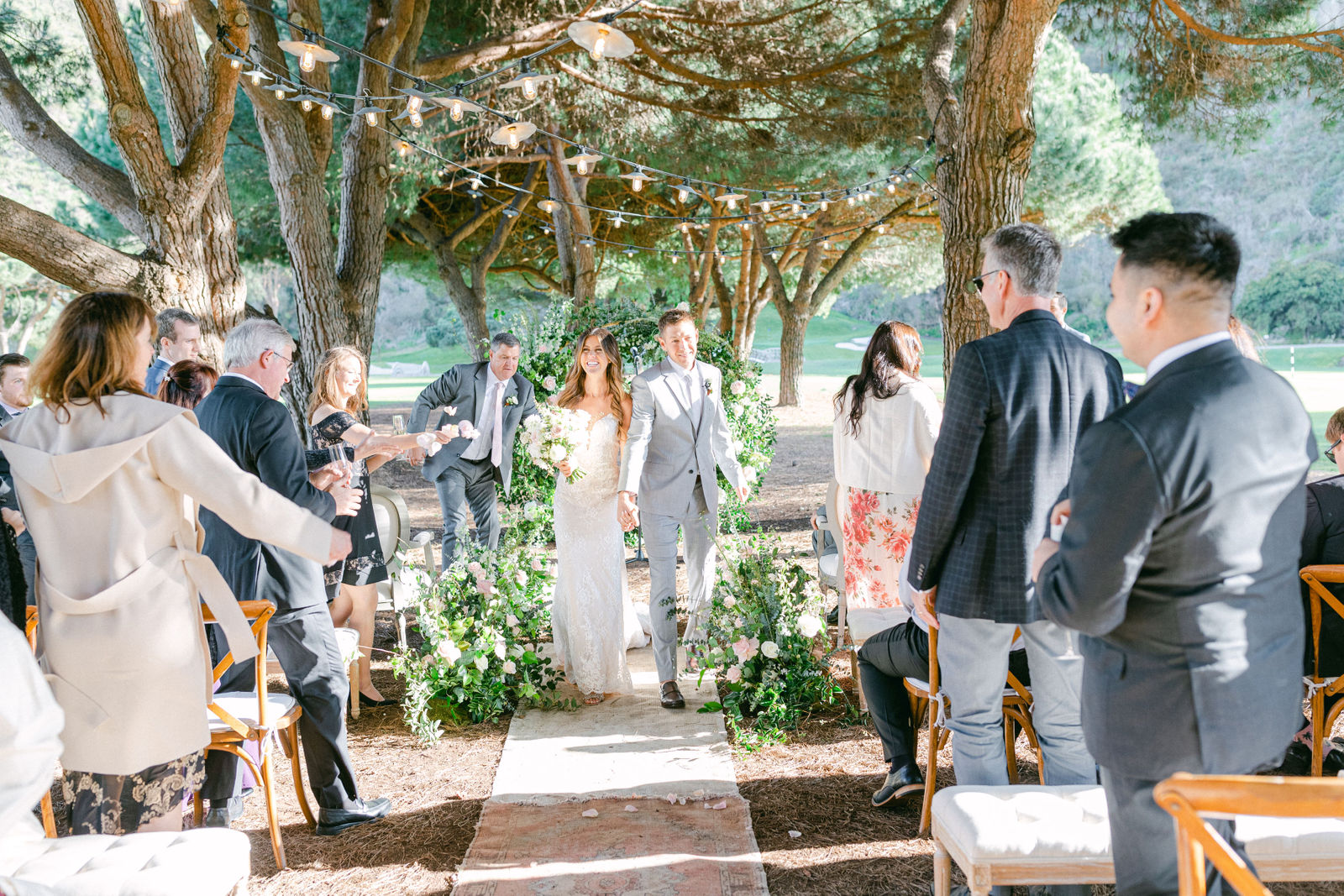 The ceremony at The Ranch at Laguna Beach, guests gathered close beneath the trees