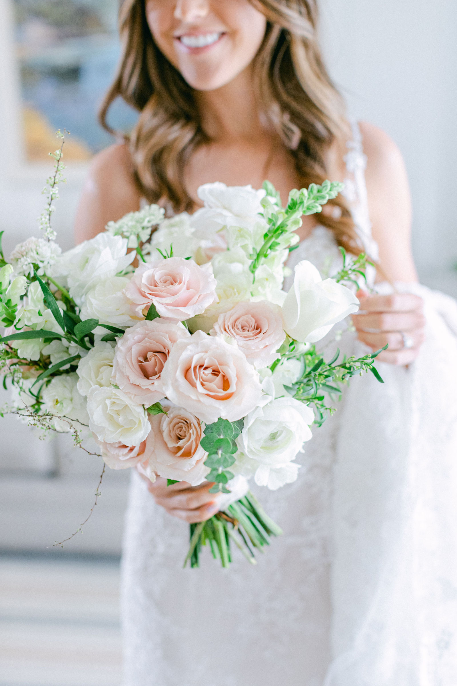 A bouquet of blush garden roses and white ranunculus