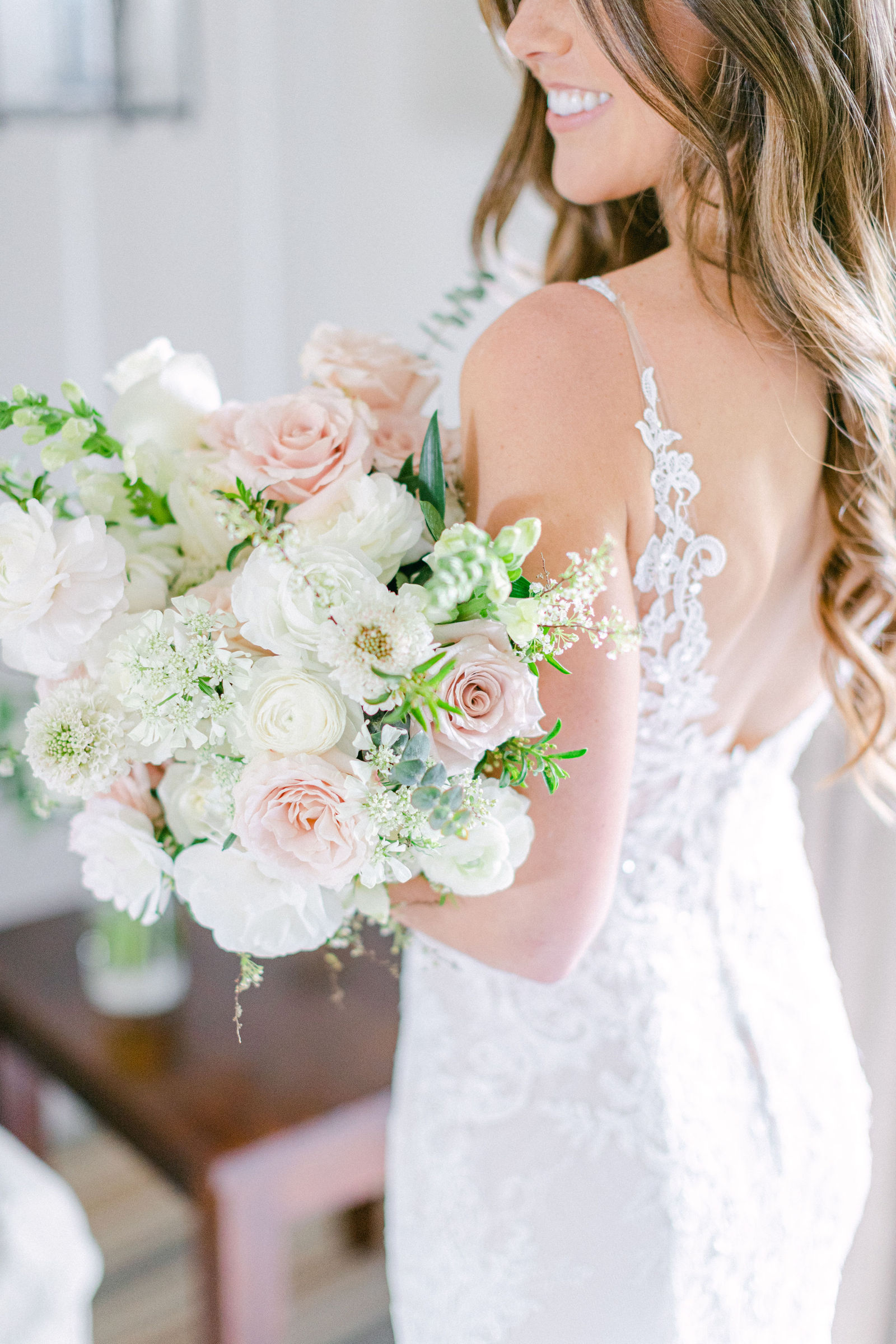 A bouquet of blush garden roses and white ranunculus