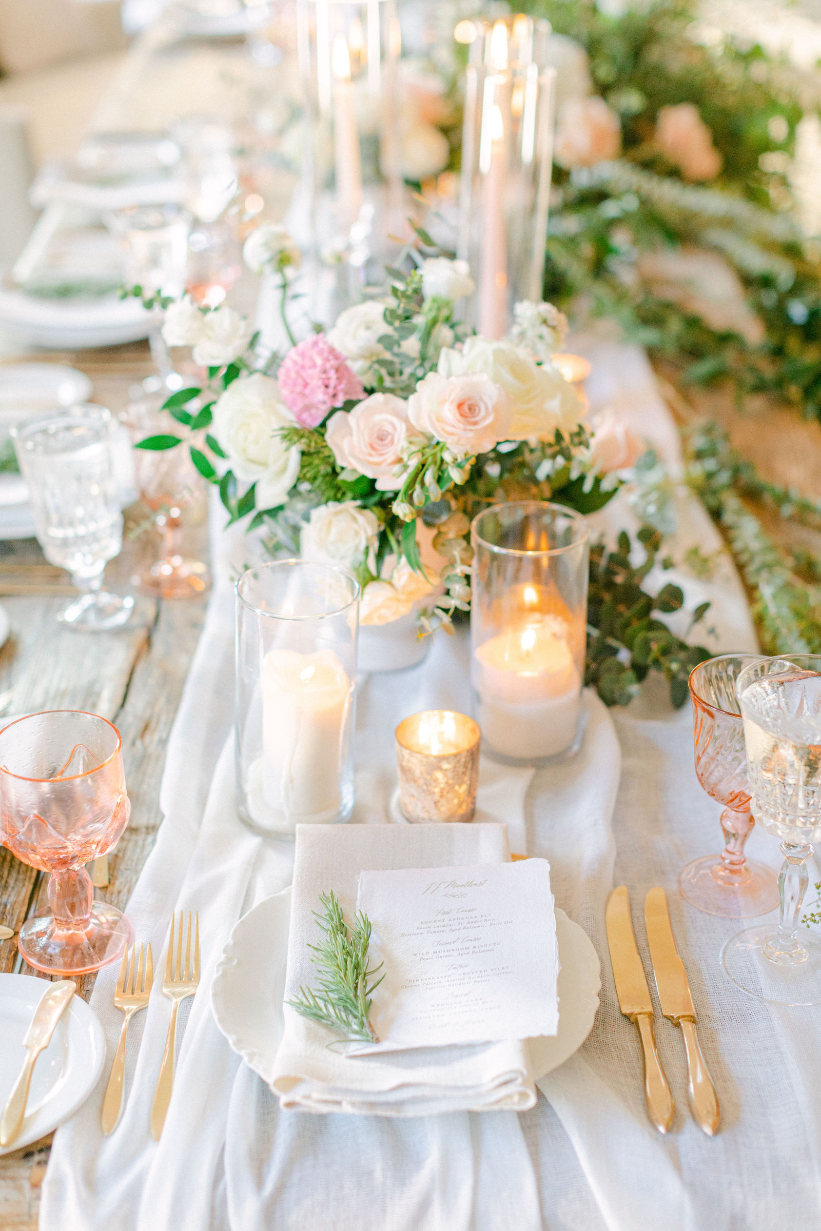 Tapers and blush garden roses down the length of the table