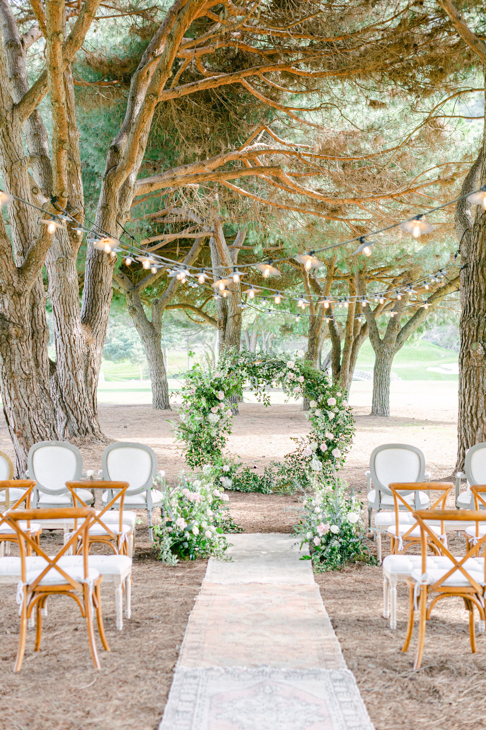 The ceremony aisle beneath the trees at The Ranch at Laguna Beach