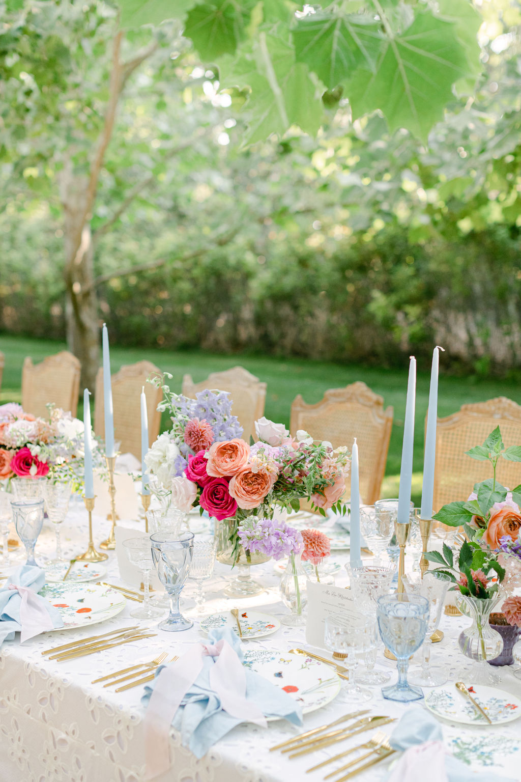 Tablescape with taper candles, garden flowers and gold flatware
