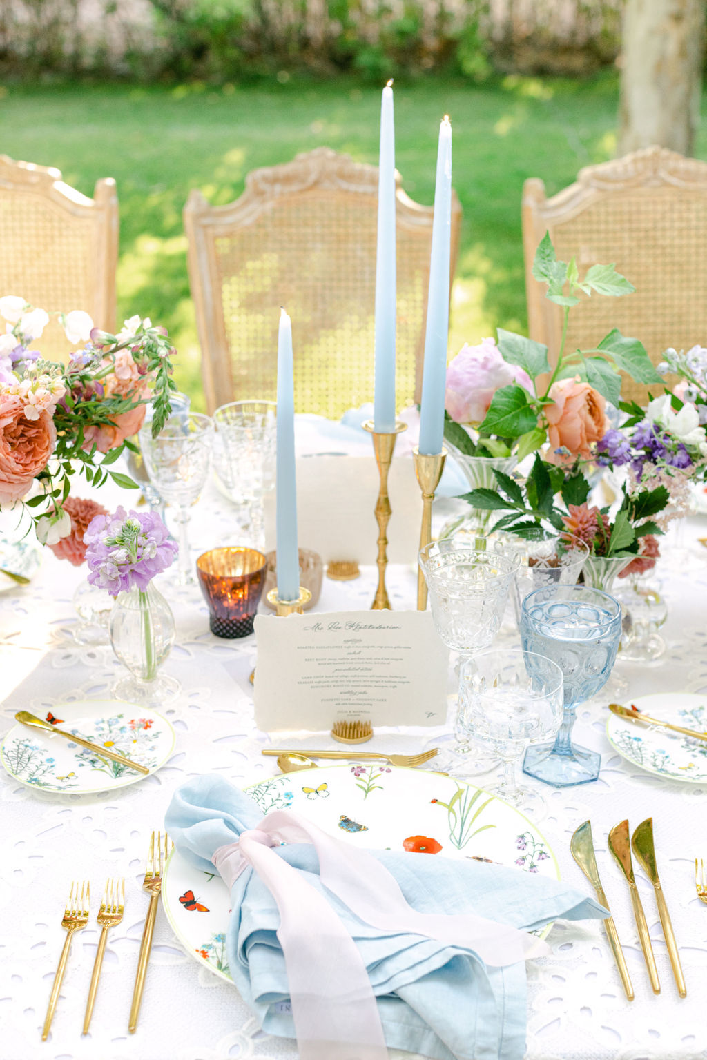 Place setting with blue taper candles and hand-lettered menu