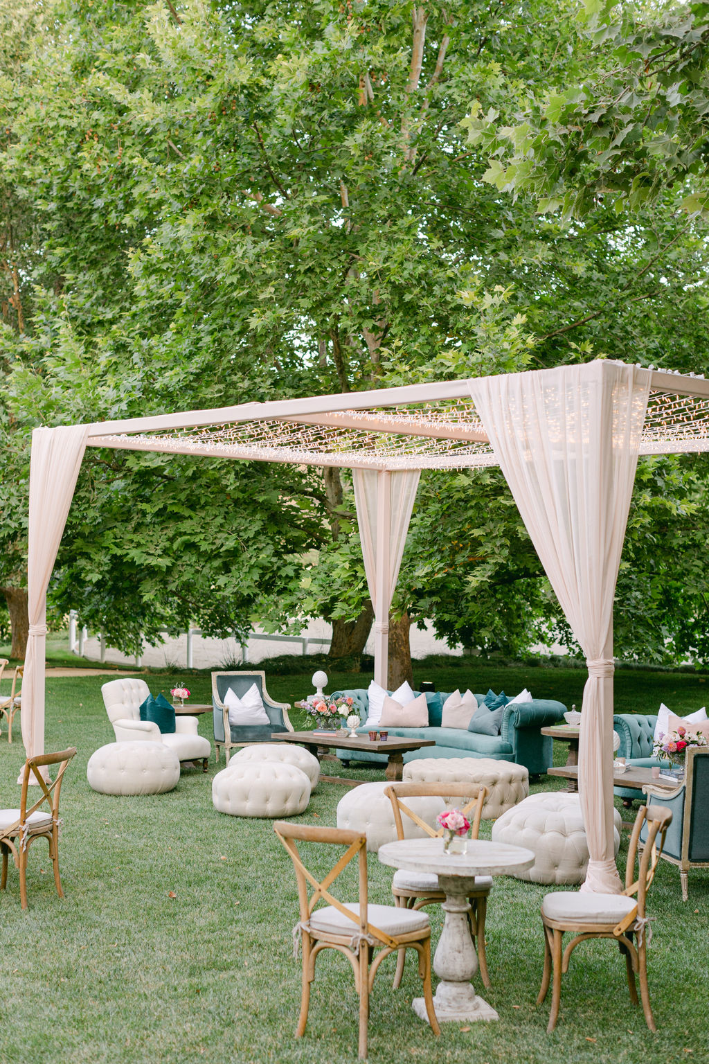 Lounge vignette beneath a draped cabana on the lawn