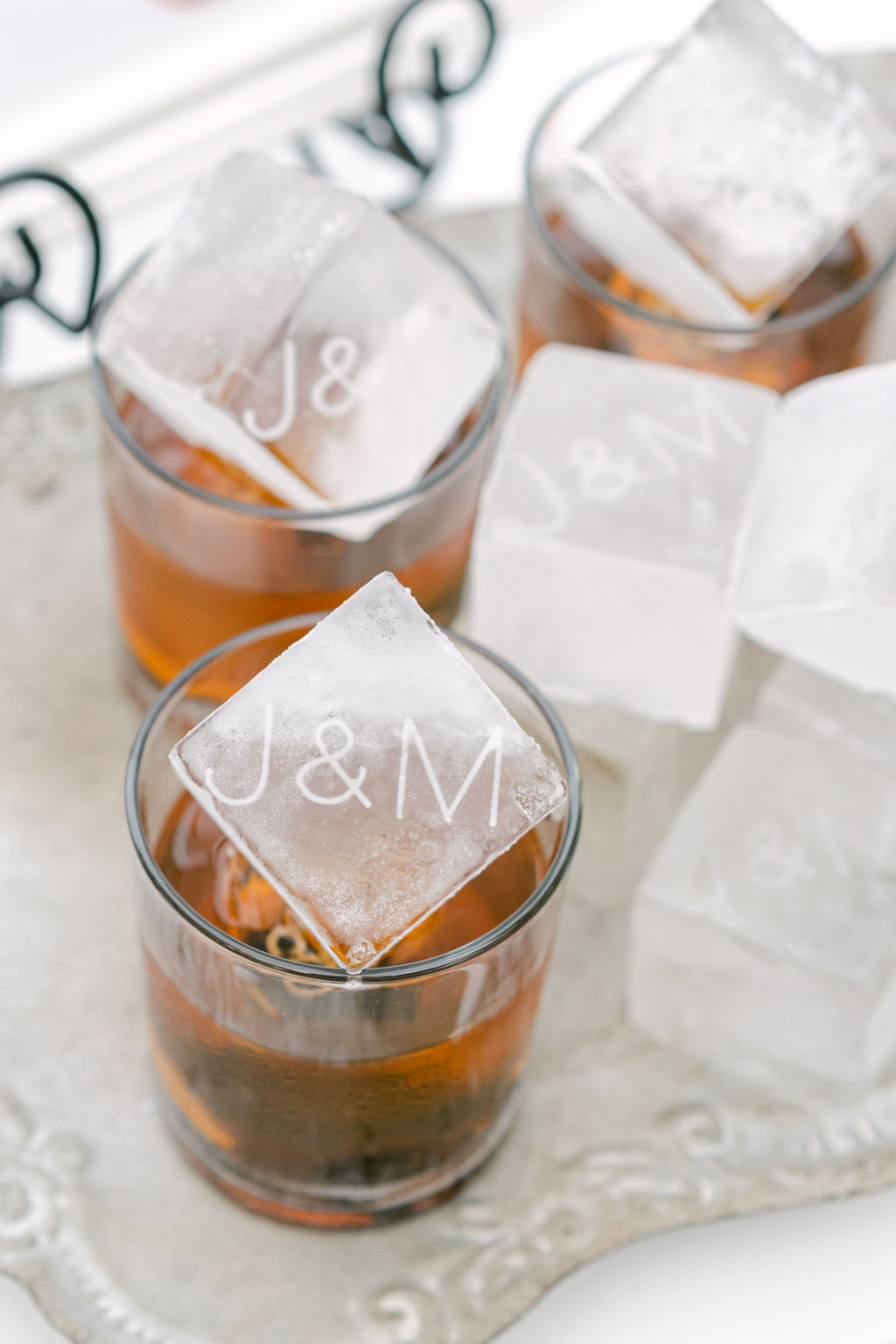 Monogrammed ice cubes in amber cocktails