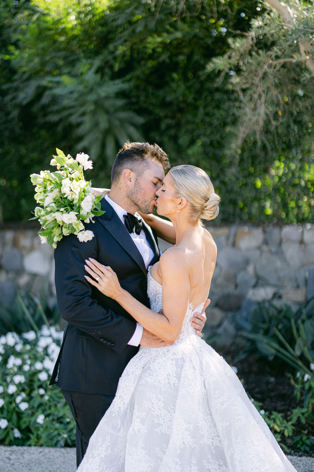 A kiss, white bouquet in hand