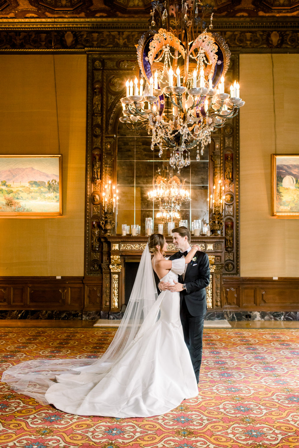 The grand paneled hall of the Jonathan Club, chandeliers lit