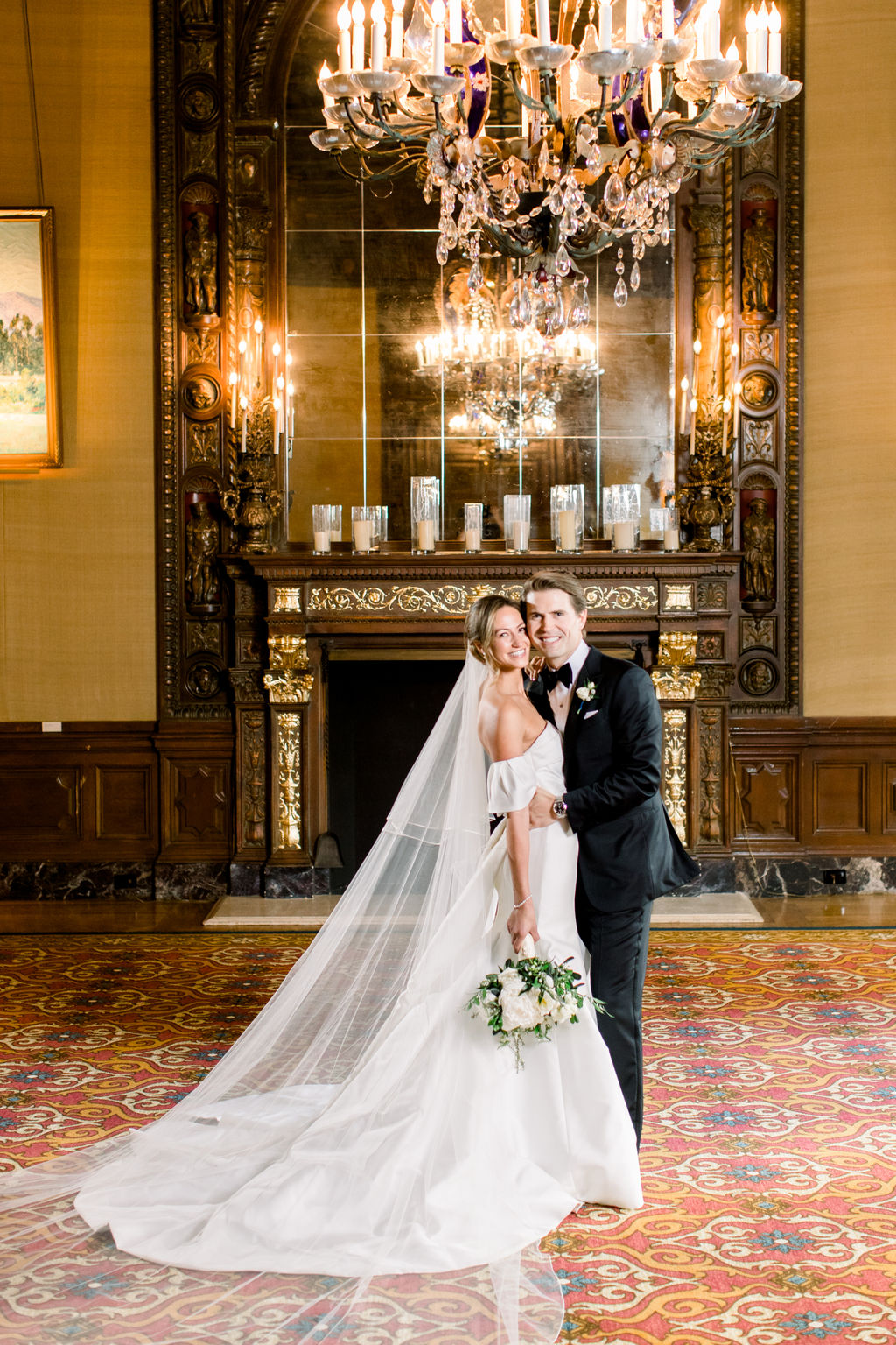 Bride and groom before the great fireplace