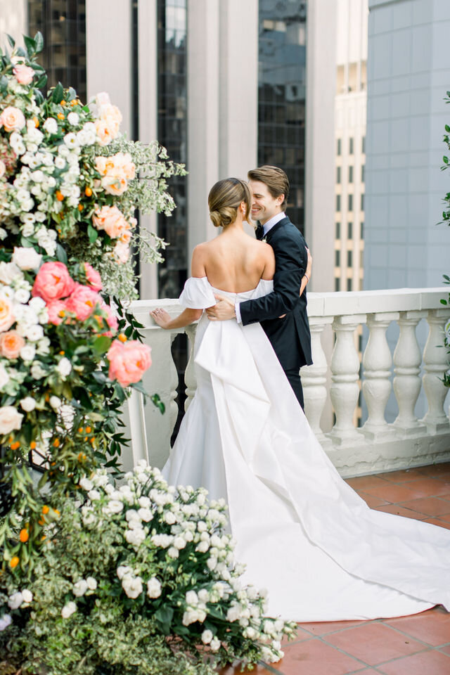 Leslie and Buddy on the balustrade at the Jonathan Club, roses climbing the column and downtown Los Angeles behind