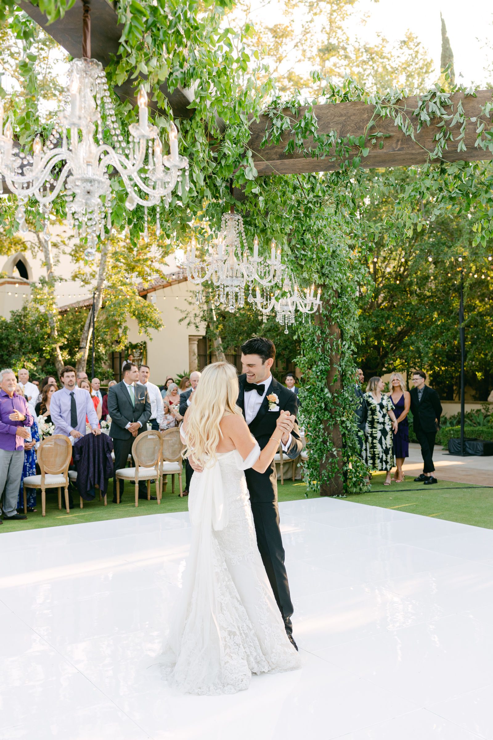 The first dance under the chandeliers, guests gathered around the floor