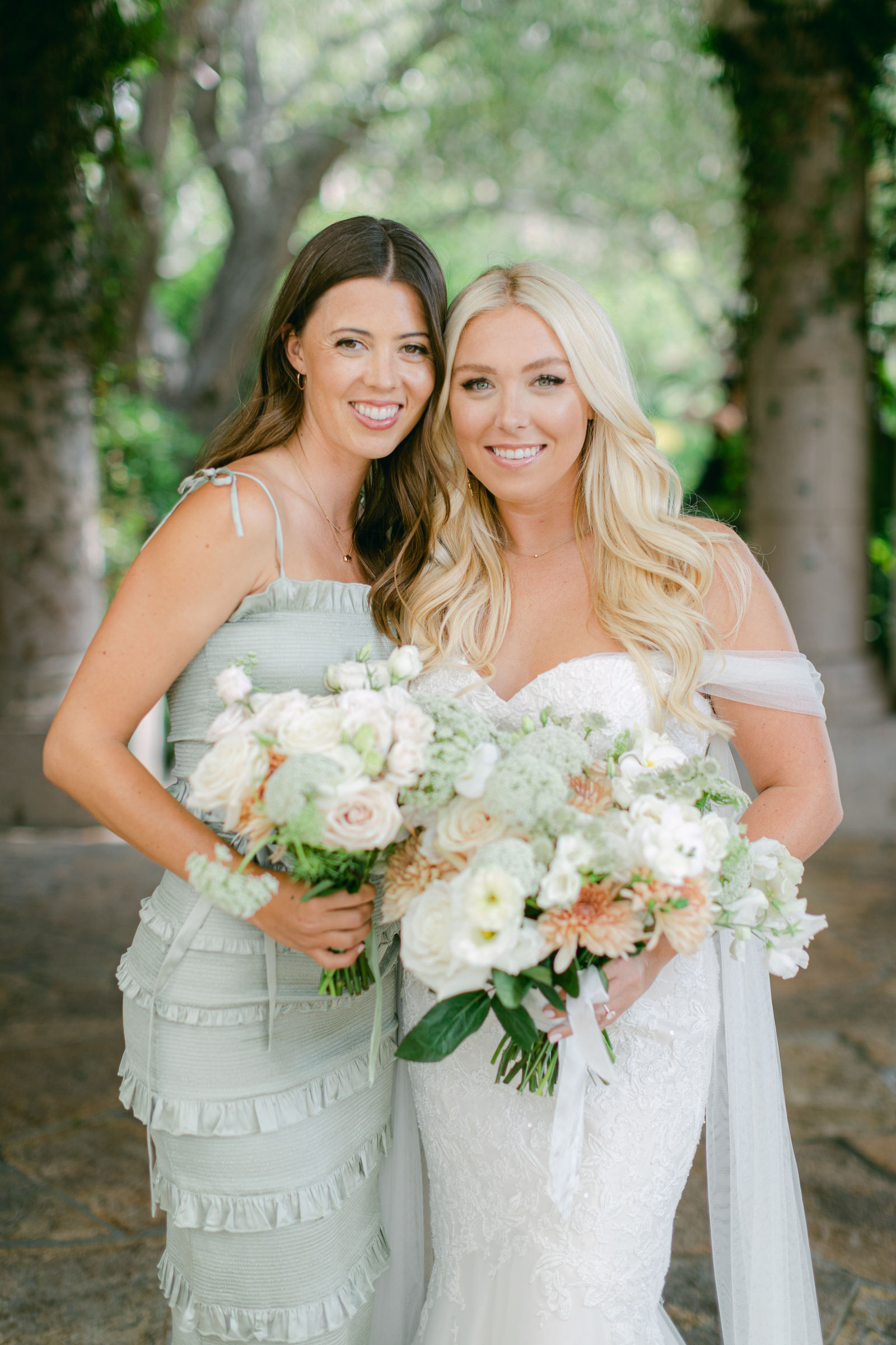 Bridesmaids in sage with white and peach bouquets