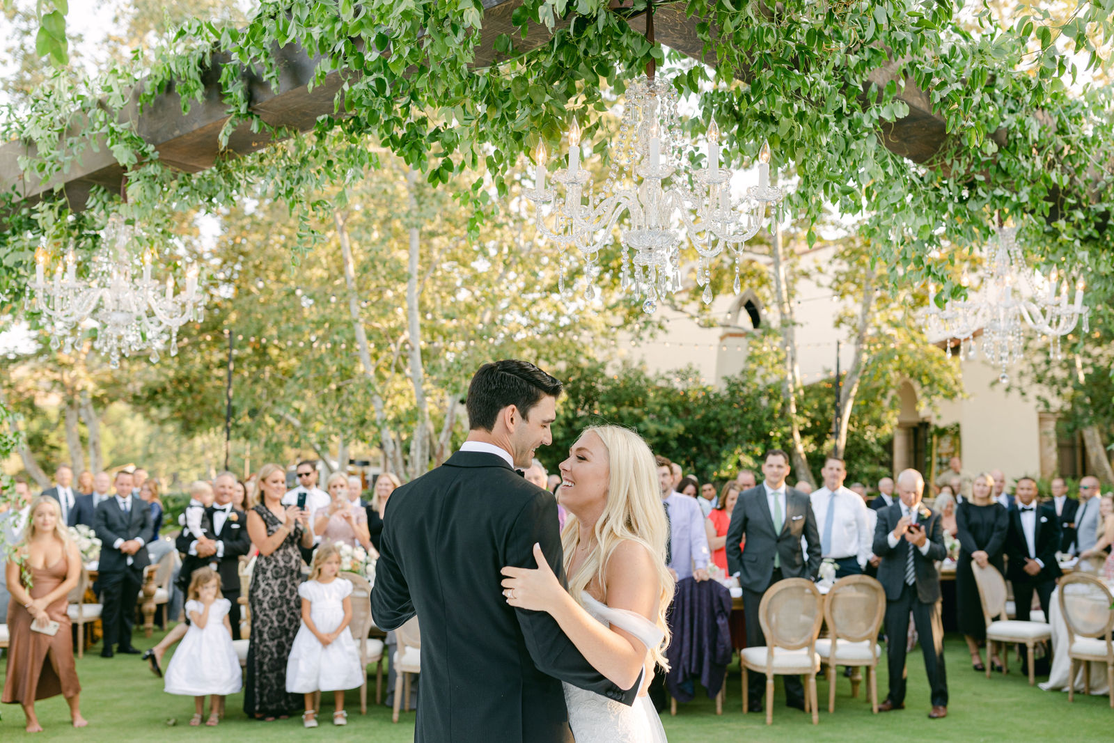 The first dance under the chandeliers, guests gathered around the floor