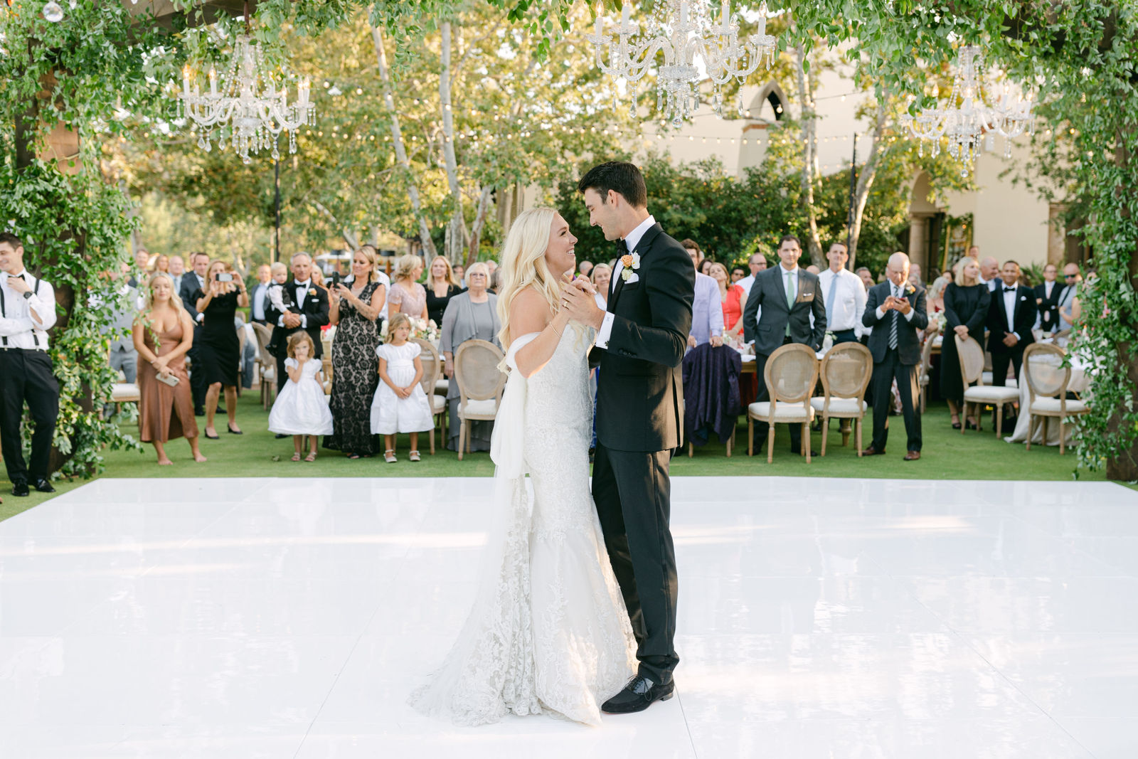The first dance under the chandeliers, guests gathered around the floor