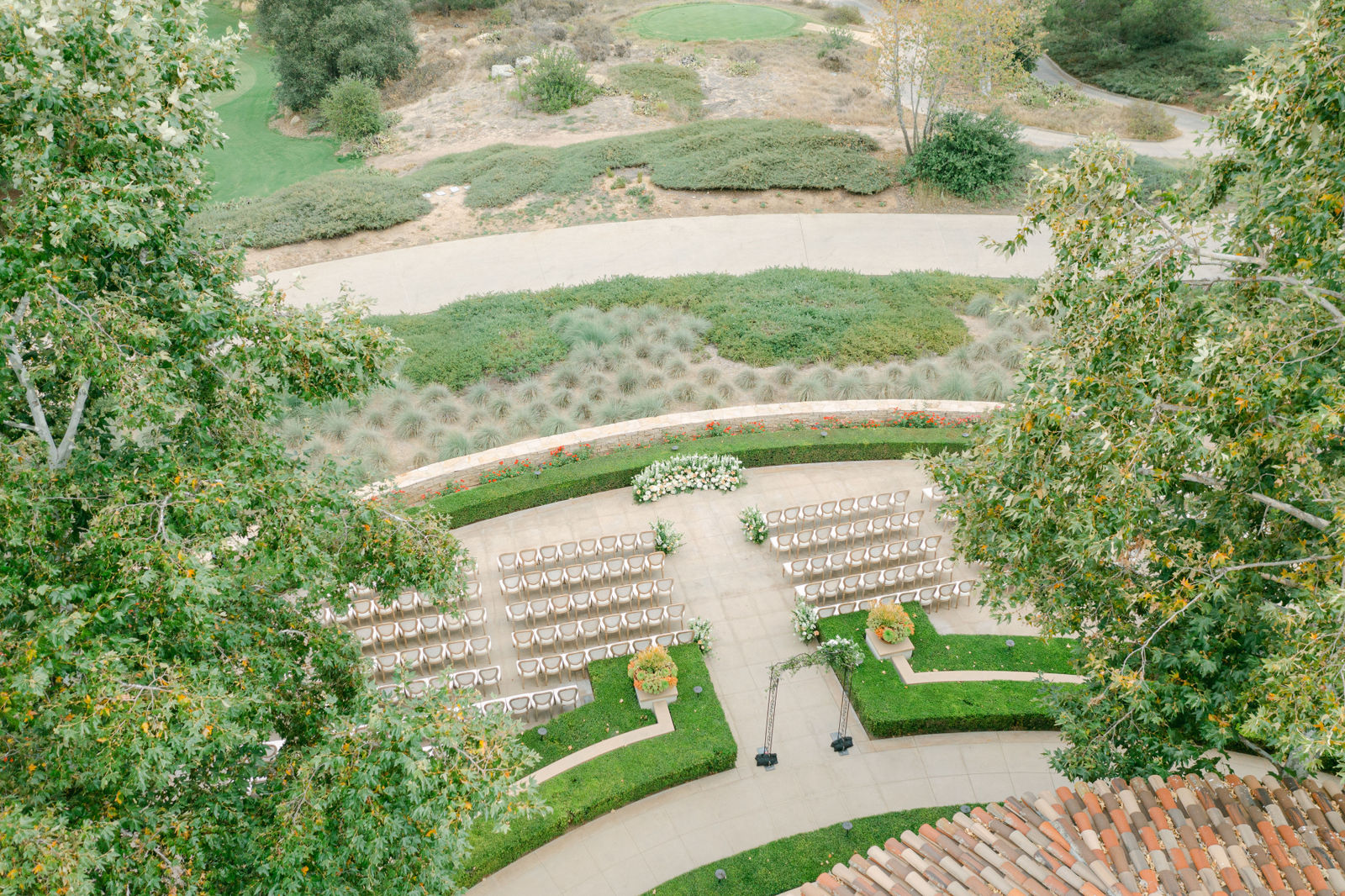 The ceremony from above at Shady Canyon, curved rows of white chairs in the hedge garden