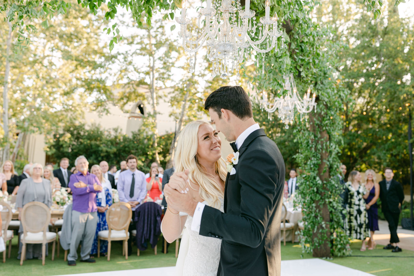 The first dance under the chandeliers, guests gathered around the floor