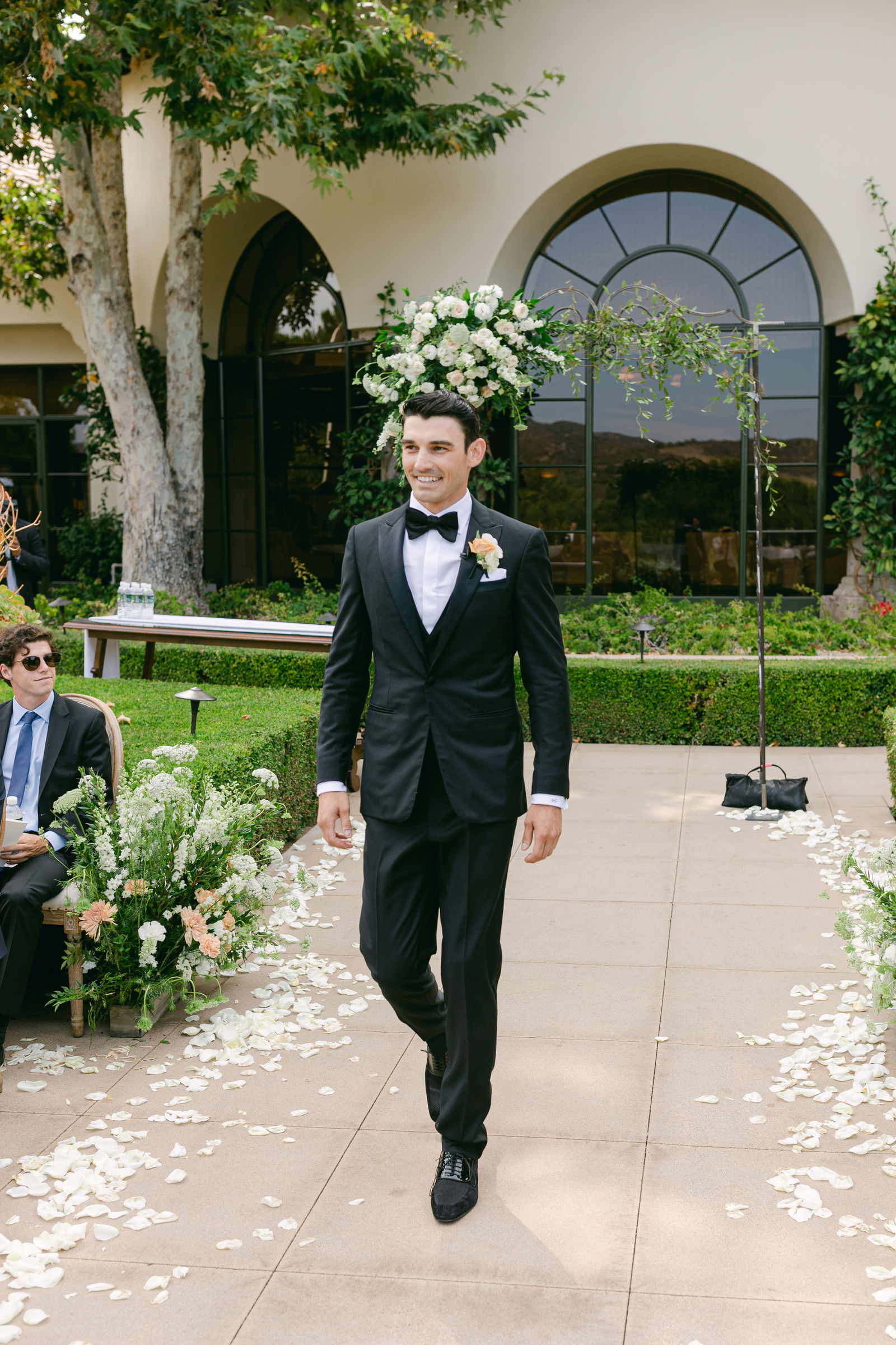 The groom and the children coming up the petal aisle