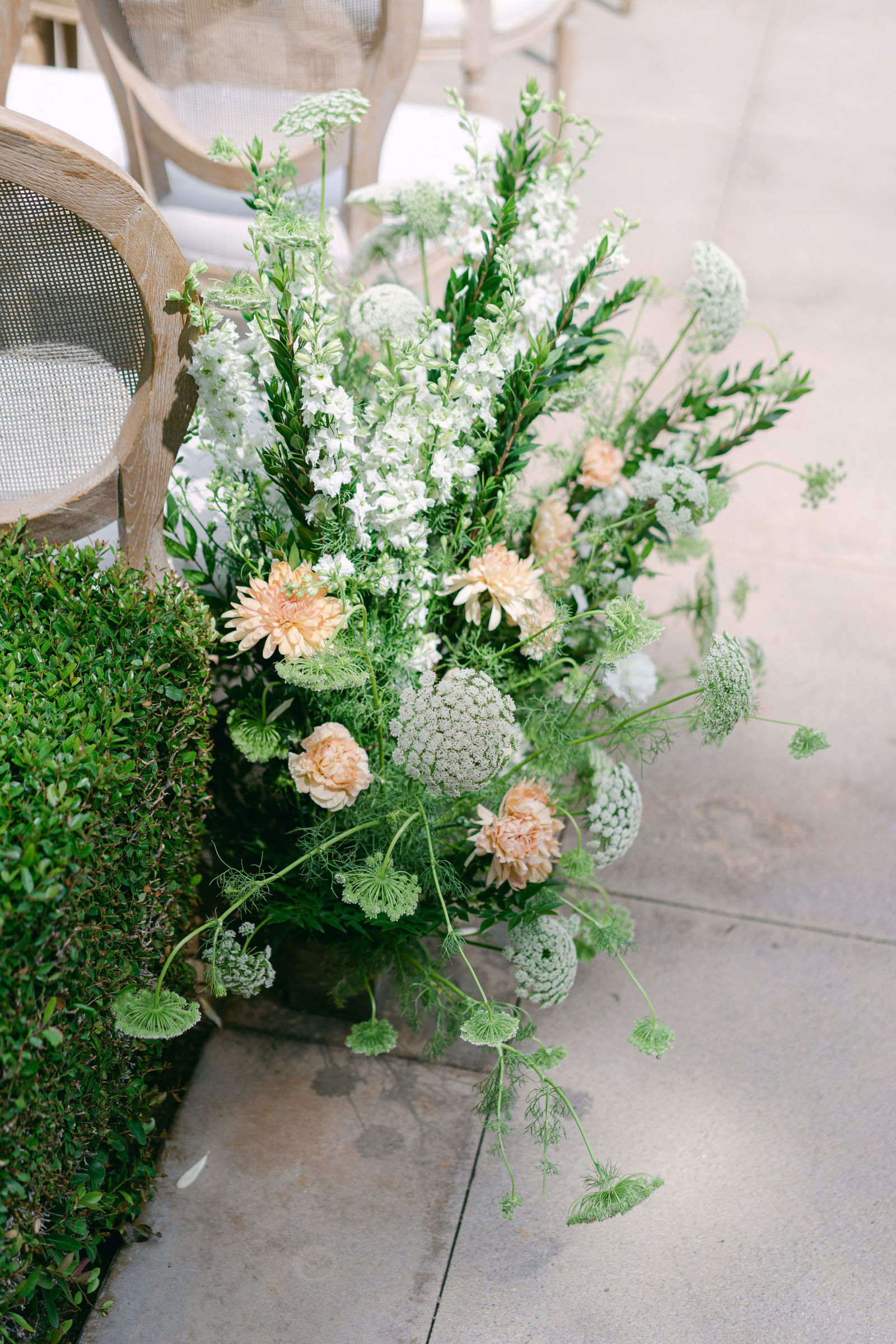 White and peach florals at the end of the ceremony aisle