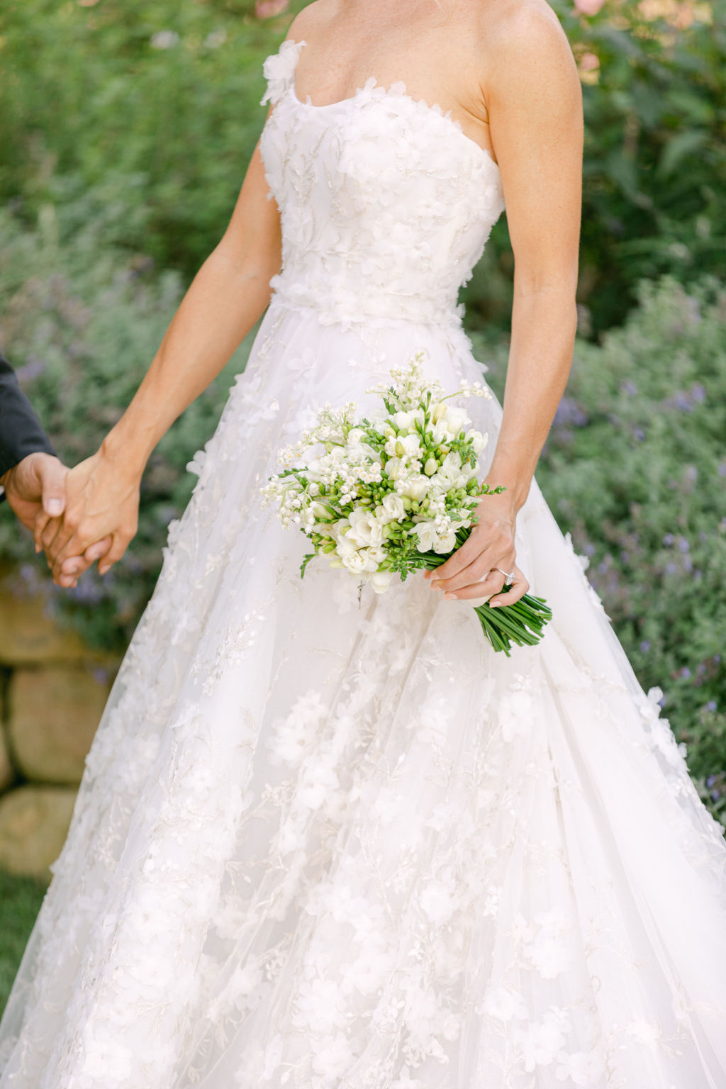 The back of the gown, bouquet in hand