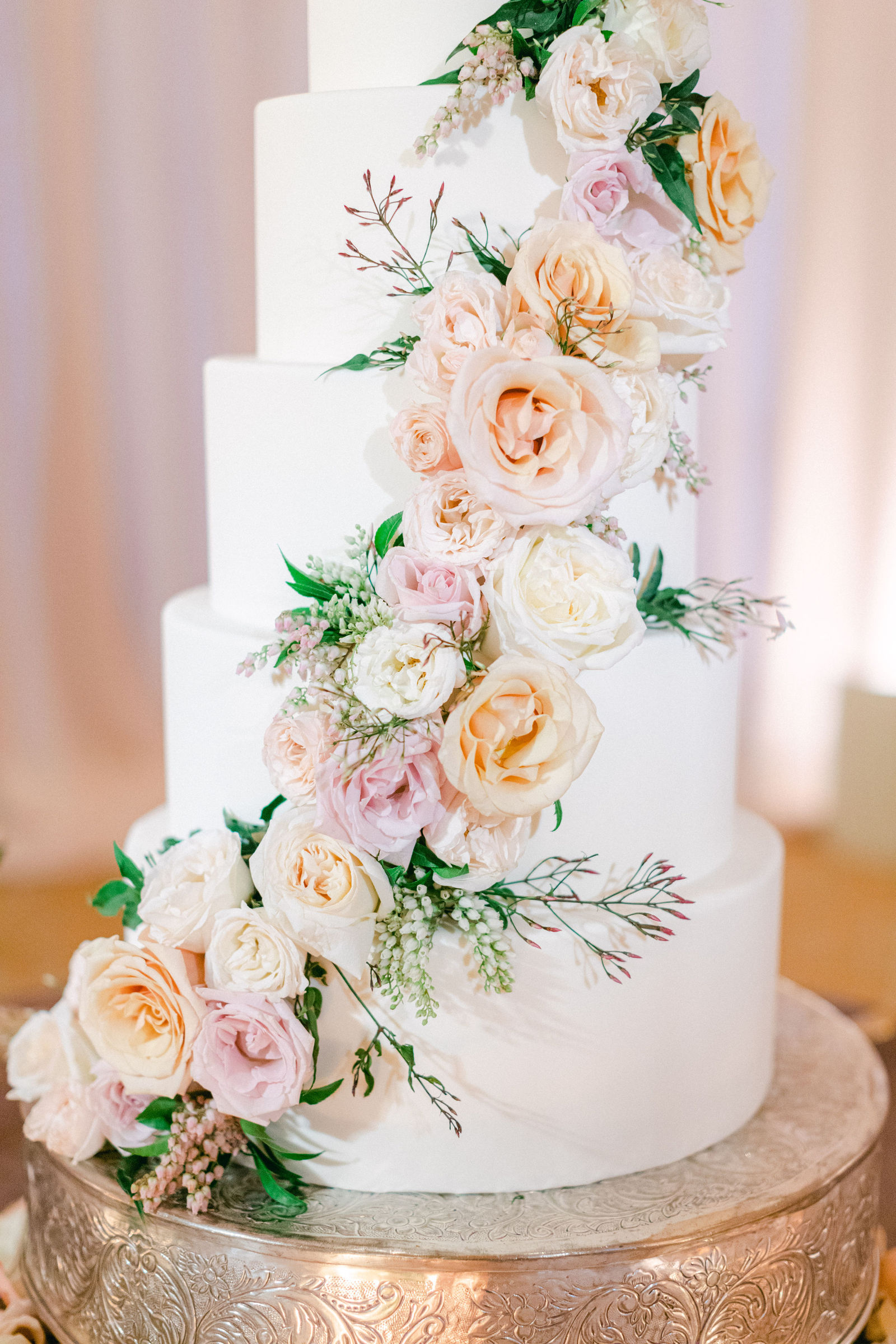Garden roses climbing the tiers of the wedding cake