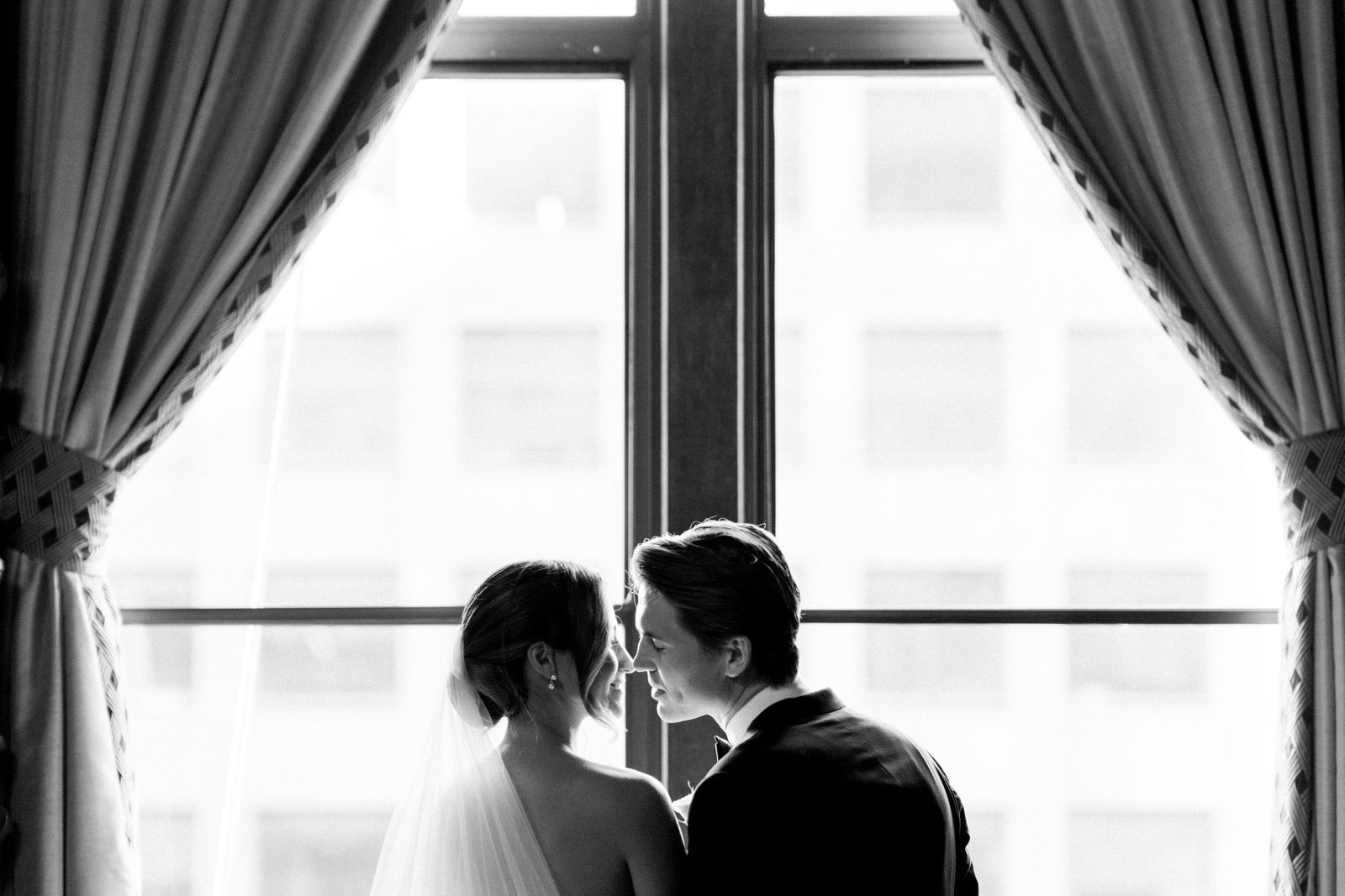 Bride and groom at a tall window of the Jonathan Club