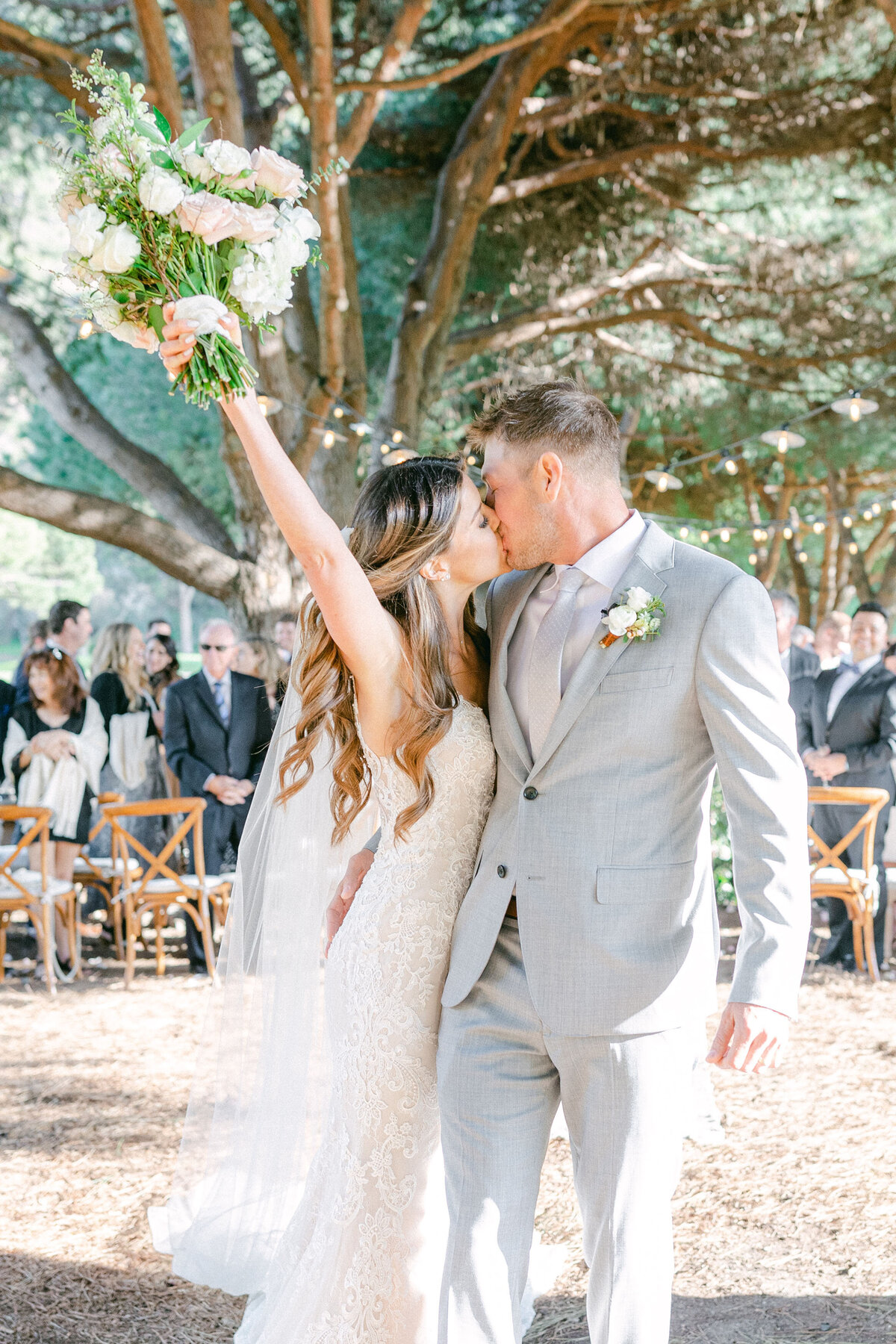 Just married: the bouquet goes up under the old pine